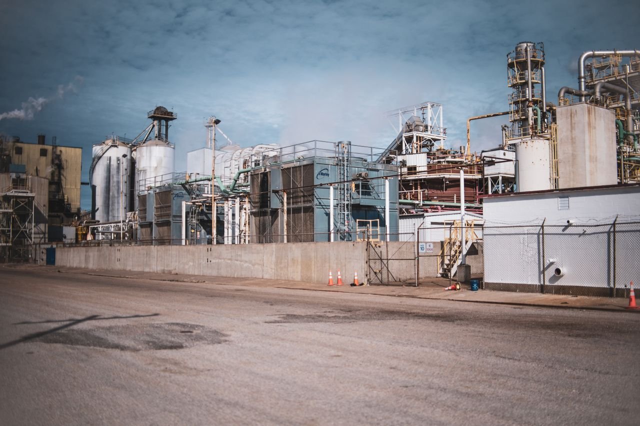A detailed view of an industrial plant with steel structures under a cloudy sky, showcasing modern industrial architecture.